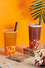 Plastic cups filled with fresh and tasty orange and grapefruit juices on the table