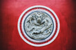© Bosse Erichsen/ADDICTIVE STOCK - Round shaped ornamental dragon relief on red wall of traditional oriental temple in Yunnan