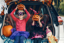 Trick Or Trunk. Children Siblings Sisters Celebrating Halloween In Trunk Of Car. Friends Kids Girls Preparing For October Holiday Outdoor. Social Distance And Safe Alternative Celebration.