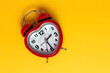 © Eduardo Lopez/ADDICTIVE STOCK - Red metal alarm clock in shape of heart placed on vibrant yellow background in studio