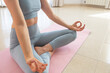 © Laura Bauza/ADDICTIVE STOCK - Crop slim female sitting on mat in Padmasana and meditating while practicing yoga at home