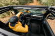 © Marcos Osorio/ADDICTIVE STOCK - From above inside view of a driver wearing a cap and sunglasses in an off-road car looking away