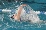 Fototapeta Łazienka - teenage girl swimming in swim meet doing backstroke