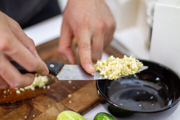 Poster - Closeup shot of a man holding a knife with chopped vegetables