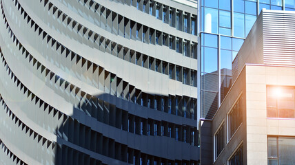 Modern architecture with sun ray. Glass and steel facade on a bright sunny day with sunbeams on the blue sky. Economy, finances, business activity concept.