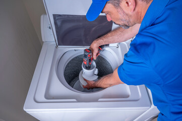 Appliance technician installing an agitator on a washing machine