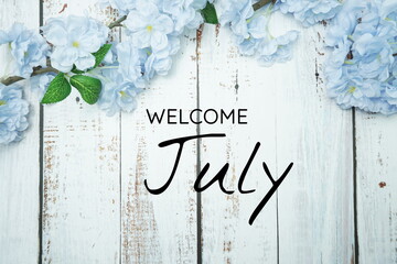 Wall Mural - welcome june text and blue flower decoration on wooden background