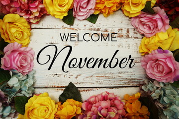 Welcome November text and Flowers Colorful Border Frame on wooden background