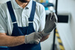 © Drazen - Cloe-up of mechanic using working gloves at auto repair shop.
