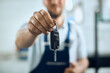 © Drazen - Close-up of  auto repairman holding car key in a workshop.