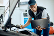 © Drazen - Auto repairman using laptop and writing data while running car diagnostic in a workshop.