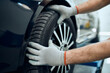 Close-up of mechanic changing car tire at auto repair shop.