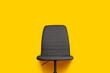 one gray fabric office chair on yellow background. Place for your text