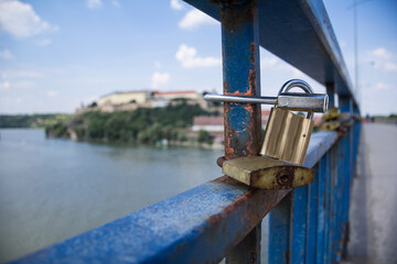 Love locks and padlocks locked on the fence and railing of a bridge in Novi Sad, Serbia next to Petrovaradin fortress. Love locks are a recent tradition of couples to show commitment...