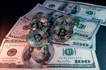 Metal shiny bitcoin crypto currency coins on US dollar bills. Electronic decentralized money concept.