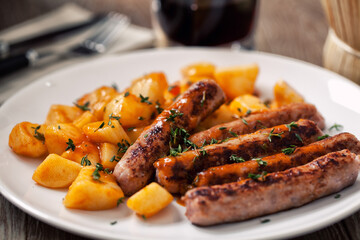 Sticker - Sausages and roasted potatoes on a plate. High quality photo.