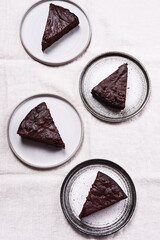 Wall Mural - Slices of rich moist chocolate cherry cake. Homemade dark chocolate sweet brownies cakes on greige linen tablecloth. Selective focus