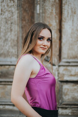 Poster - Gorgeous Caucasian female in stylish purple and black outfit posing on background of a grungy wall