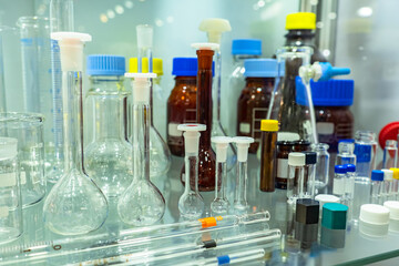 Poster - lab test tubes on a glass shelf. various laboratory glassware. medical flasks and jars close-up. con