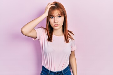 Sticker - Redhead young woman wearing casual pink t shirt confuse and wonder about question. uncertain with doubt, thinking with hand on head. pensive concept.