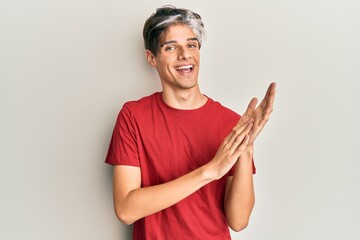 Sticker - Young hispanic man wearing casual clothes clapping and applauding happy and joyful, smiling proud hands together