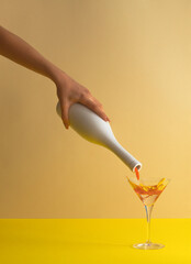 Wall Mural - Bottle pouring petals of flower into the martini glass. Party summer concept.