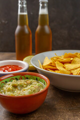 Poster - Vertical shot of two bottles of beer with chips, salad and ketchup on bowls with a sliced lemon