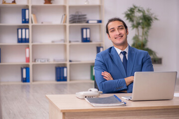 Young male employee sitting in the office