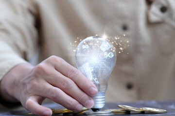 Poster - Businessman holding futuristic light bulb with ideas and innovative technology, New ideas for business and finance concept