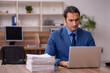 © Elnur - Young male employee and a lot of work in the office