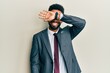 © Krakenimages.com - Handsome hispanic man with beard wearing business suit and tie covering eyes with arm smiling cheerful and funny. blind concept.