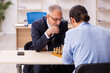 © Elnur - Two businessmen playing chess in the office