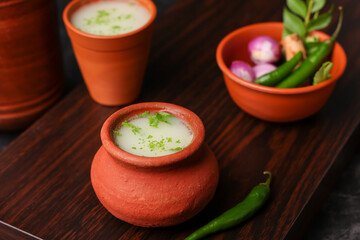 Wall Mural - Spiced buttermilk in clay pot , chaas , chaach , moru , sambharam , curd, lassi , yogurt, cool refreshing drink for hot summer in glass , Kerala, India Sri Lanka. Flavored Indian buttermilk.	