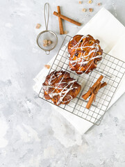 Two sweet buns with vanilla icing on gray background, top view, with copy space