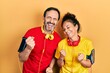 © Krakenimages.com - Middle age couple of hispanic woman and man wearing sportswear and arm band very happy and excited doing winner gesture with arms raised, smiling and screaming for success. celebration concept.