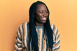 © Krakenimages.com - Young black woman with braids wearing casual winter sweater looking away to side with smile on face, natural expression. laughing confident.