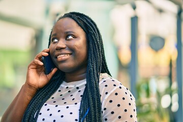 Poster - Young african american woman smiling happy talking on the smartphone at the city.