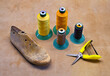 Boot maker tools. Bootmaker equipment on leather underlay. Sewing things with boot-tree. Sewing thread with the shoelast. Shoetree with hand shears and coloured sewing thread. Shoemaker's scissors