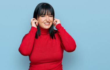 Poster - Young hispanic woman wearing casual clothes covering ears with fingers with annoyed expression for the noise of loud music. deaf concept.