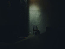 One Chair Stands In The Middle Of A Dark Room Silhouette Of A Falling Light Interior