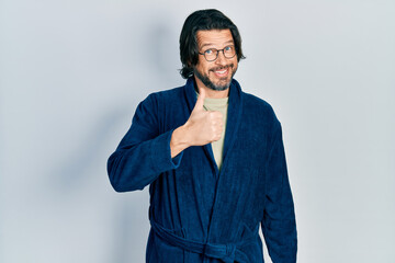 Sticker - Middle age caucasian man wearing bathrobe and glasses doing happy thumbs up gesture with hand. approving expression looking at the camera showing success.