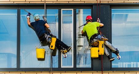 Two men cleaning windows on an office building