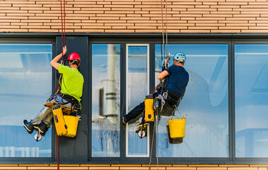 Two men cleaning windows on an office building