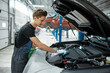 Male mechanic closes the hood, car service