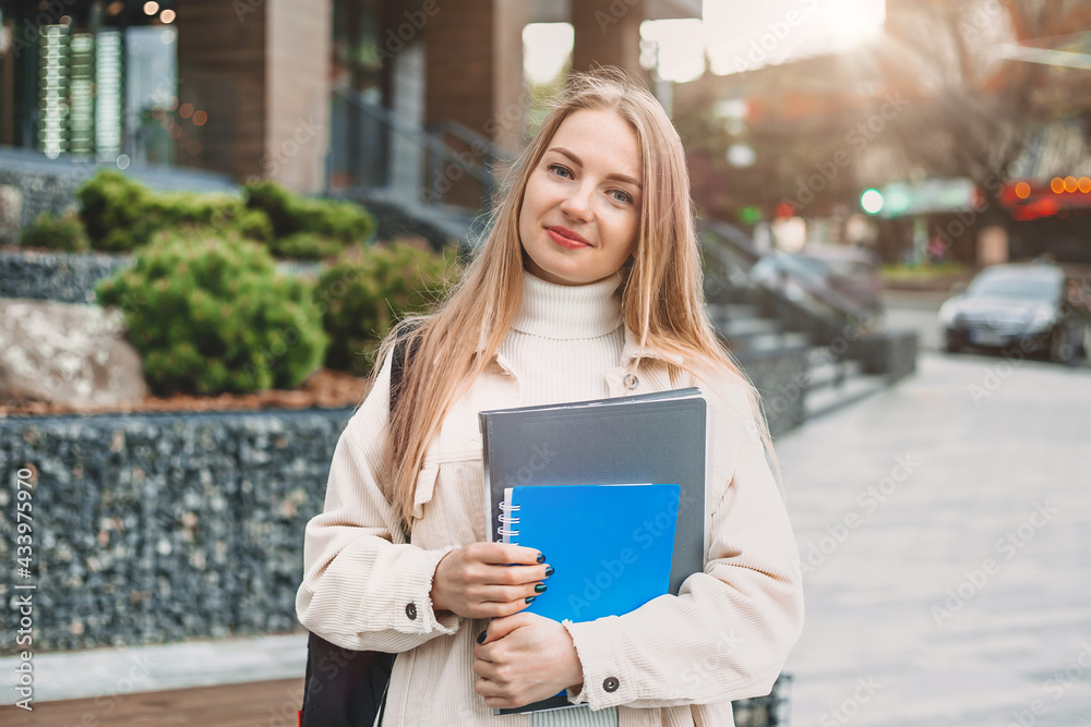 Education concept. Happy student girl holds folders notebooks books in ...
