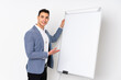 © luismolinero - Young caucasian handsome man isolated on purple background giving a presentation on white board