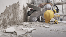House Renovation Concept, Construction Worker Use Computer, Protective Construction Work Tools, Helmet, Yellow Headphones And Glasses In Background