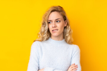 Poster - Young blonde woman isolated on yellow background with confuse face expression