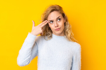 Poster - Young blonde woman isolated on yellow background with problems making suicide gesture