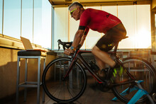 Senior Man Cycling Bike During Home Online Workout